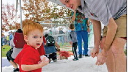 Chris Harris plays in the snow with son Dawson. Hundreds of families stood in line for their chance to experience the frosty playground.