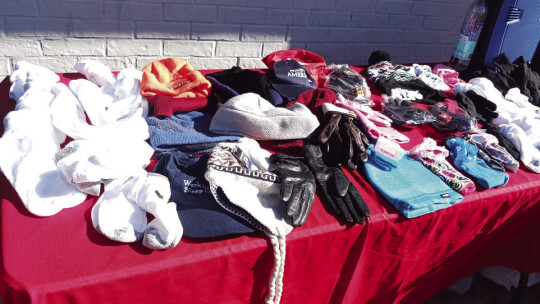 Assorted gloves, hats and other cold-weather gear is displayed at a Winter Coat Give Away Dec. 17, sponsored by the local restaurant Seed to Soul Food and 10,000 Fearless First Responders. Facebook/SeedToSoulFood