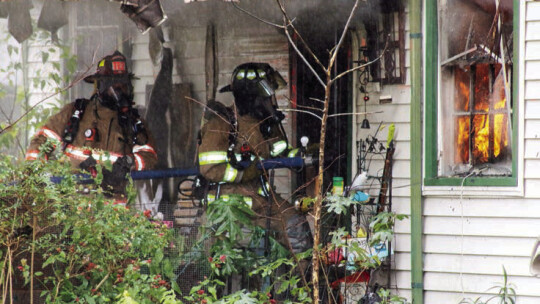 Taylor firefighters attack a fire from the outside but are prepared to enter the house to bring down the flames. Photos by Jason Hennington