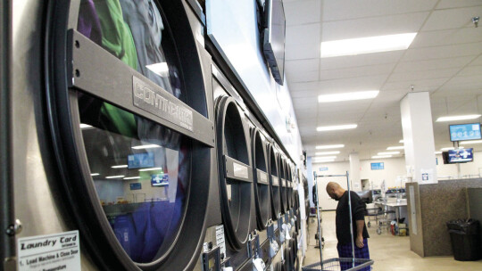 A client waits for his clothes to dry at Skyline Laundry Nov. 28. Skyline Laundry hosts Laundry Love each month, which allows clients to wash clothes for free. Photo by Nicole Lessin