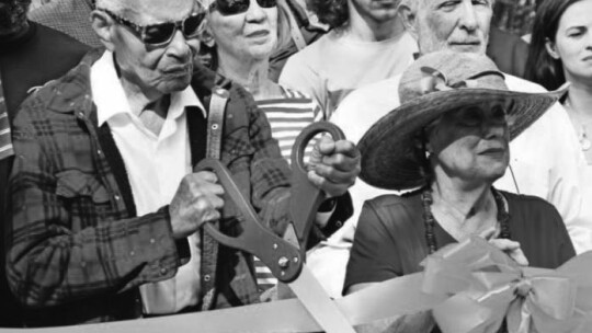 Ernest Rector (left) cuts the ribbon held by Frances Sorrow during the re-dedication of the Dickey Bridge. Photo by Jason Hennington