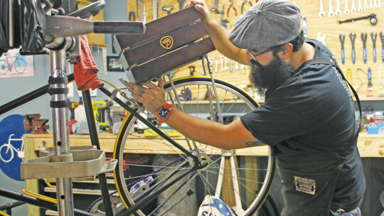 Eddie Chavez works on installing a bike basket Dec. 29 for a customer. Photo by Nicole Lessin