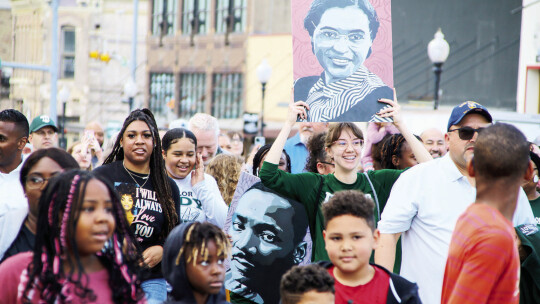 In celebration of Dr. Martin Luther King Jr. Day, people marched from the Dickey Givens Community Center to Heritage Square. Along with images of Dr. King, there were also paintings of other civil rights icons such as Rose Parks. Photo by Jason Hennington