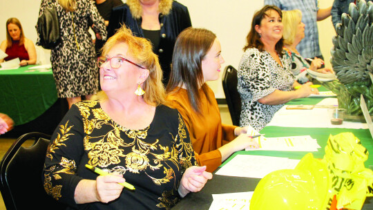 Chamber Ambassador of the Year Laurie Gerberding (front) works the sign in table at the Chamber banquet with other Chamber ambassadors. Photo by Nicole Lessin