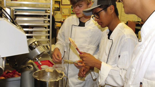 Student chefs mix ingredients for sugar cookies that will be given to Taylor High School staff members as holiday treats.