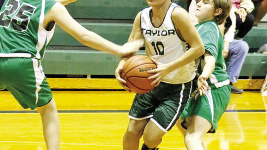 Da’vion Kuhn splits two Burnet defenders to get to the basket during the seventh grade A team’s 61-6 win Thursday night.