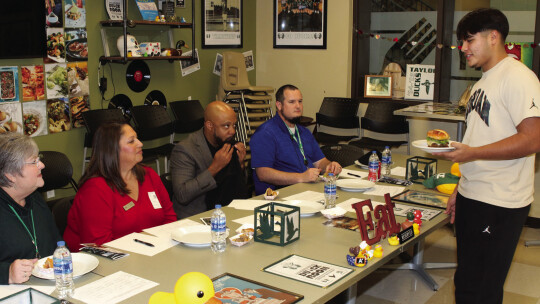 Culinary student Nick Walker presents his burger creation to the judges at Taylor High School’s Burger Challenge. From left are school board members Anita Volek and Cheryl Carter, THS principal Matt Wamble and assistant principal Sean Schobinger. Photos by Tim Crow