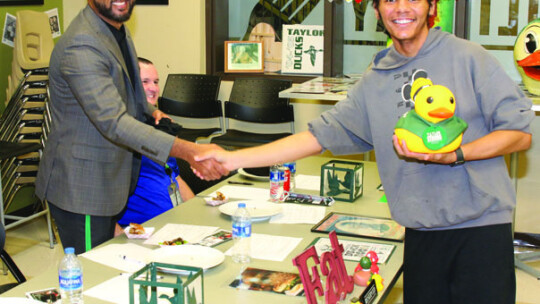 Alex Ramirez is congratulated by THS Principal Matt Wamble as the Top Chef in the Duck Brigade’s Burger Challenge.