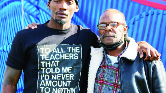 Fred and Rickey Kerley pose for a photo in front of the mural of the Olympic silver medalist. Photo by Jason Hennington