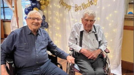 Albert Hajda sits left of Alfred Meiske in front of birthday decorations. photos by Grace Horvath