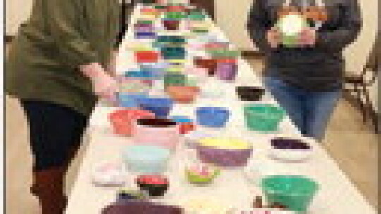 HRC executive director Donna Jones and HISD board president Billie Logiudice inspect some of the hand-crafted bowls made for the event by HISD students.