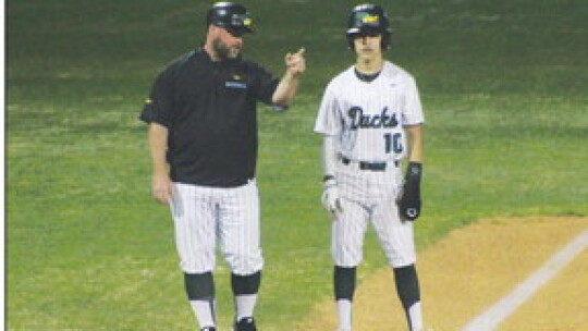 Ducks head coach Justin Adams running down the strategy with Xavier Juarez before stealing home for another run. Photo by Evan Hale