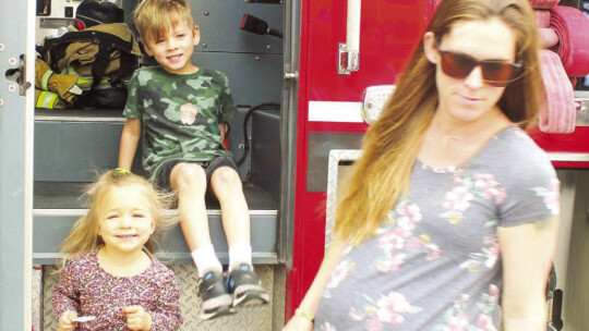 Sophia, 3, and Alex, 5, Loveless exit a fire truck during the Truck Petting Zoo last spring.