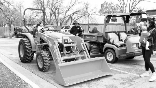 Everett Kuykendall, 4, gets behind the wheel of the number-one selling tractor in the United States as Ewald Kubota sales representative Troy Wade and mom Alicia Perez and baby sister Wren look on.