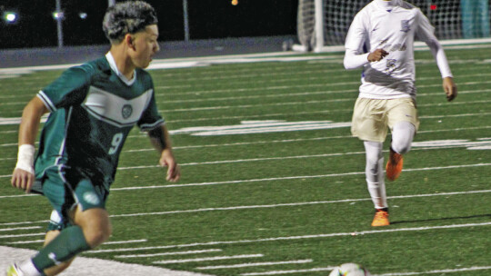 Ducks sophomore Vincent Aguilar running towards a loose ball before passing to an open teammate. Photo by Evan Hale