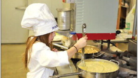 Harper Doss stirs the sauce for her broccoli and rice casserole.