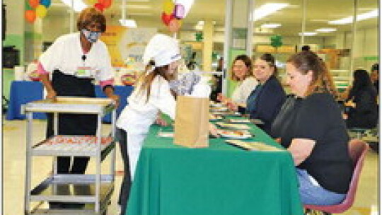 Future Chef, Harper Doss, serves her side dishes, honey roasted carrots and broccoli rice casserole, to the judges. She is assisted by Sodexo mentor, Kameshia Randel. Photos by Tim Crow