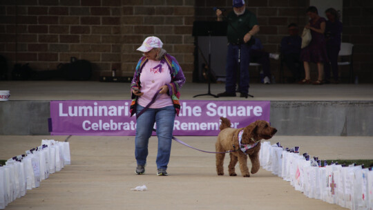 Above: Teri Rhinehart walks her dog as she looks at the decorated luminaries.