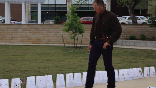 Left: Jeremy Moehnke admires the luminaria bags along the sidewalk. His parents passed away, and this was an event his mother wanted to attend. Moehnke said he brought his mother’s spirit to the event.