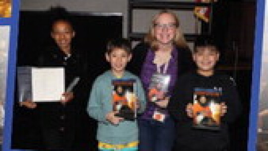 Pasemann Elementary teacher, Sarah Williams, and students, Camille Blaylock, Dresden Pebworth and Erik Perez display books autographed by astronaut Jose Hernendez that they received at the Creating A Culture of Stem presentation.