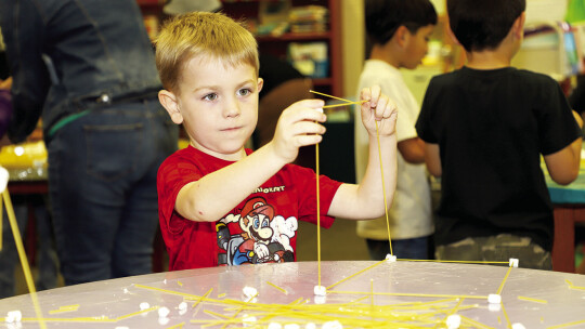 Oliver Shelander concentrates on the structure he is building at the engineering session of T.H. Johnson Elementary’s career day.