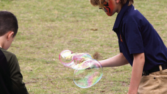 Gideon Ripple (right) tries to blow the biggest bubble he can while playing with other children.