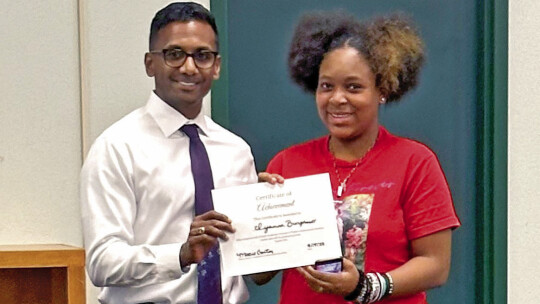 Iyanna Burghardt (right) receives her certificate of completion from Superintendent Devin Padavil.