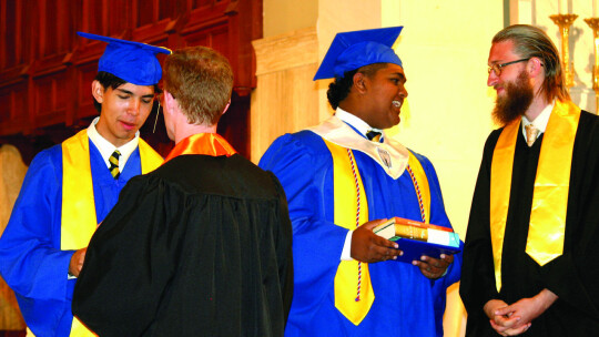 Alex Gauna (from left), Christopher Boardman, Daniel Vincent and Andrew Kinney interact after they recieved the final graduation gift of two books for their college dorm bookshelf. Photos by Grace Horvath