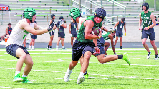 Ducks varsity football senior Jackson Meller makes a move to avoid a defender on Saturday during Taylor’s 7-on-7 scrimmage vs. Burnet.