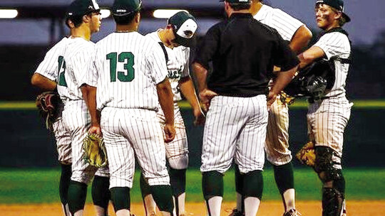 Taylor High School varsity baseball head coach Justin Adams meets his infielders on the mound on April 4 during the Ducks’ 7-2 home victory over district foe La Grange High School. Photo by Ryan Newsom