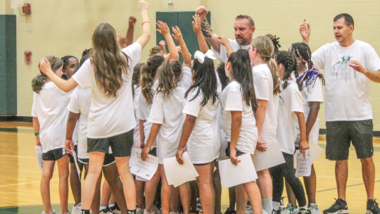 Taylor High School girls varsity basketball assistant coaches Jeff Fisher (center) and Jay Reed (right) gather the younger group of campers around on Thursday, June 8 on the final day of Lady Ducks Youth Basketball Camp. Photo by Andrew Salmi