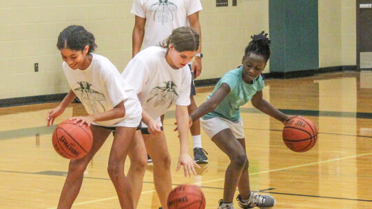 Taylor High School girls varsity basketball head coach Lawrence Bailey watches an older kids group do a dribbling skills exercise on June 8 during the Lady Ducks Youth Basketball Camp