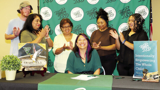 Robyn Fernandez is congratulated by family members after signing a contract to teach with Taylor ISD next school year.