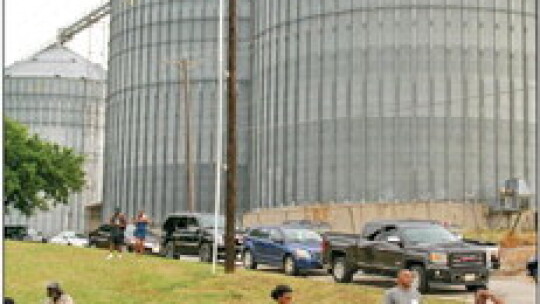 Attendees gather with lawn chairs and beverages next to grain silos at Fannie Robinson Park to listen to Jabo and the Old Dogs play blues, 206 S. Dolan St. Photo by Grace Horvath