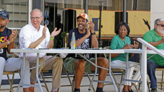 Juneteenth parade judges (from left) Taylor High School Principal Matthew Wamble, Mayor Brandt Rydell, Ricky Gray, Leslie Hill and Jose Orta applaud entries as they passed City National Bank. Photo by Jason Hennington