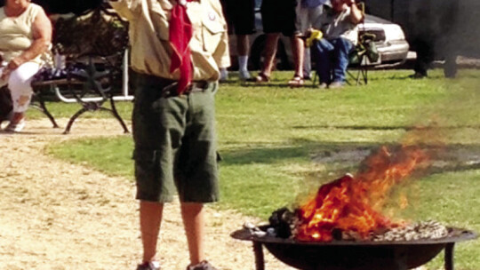 Rojas, age 11, participates in a flag retirement ceremony through Troop 167 of the Boy Scouts of America.