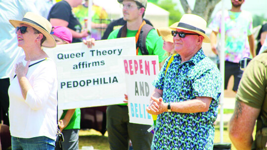 Caleb Ripple holds sign that reads “Queer Theory Affirms Pedophilia” during the beginning of the Pride festival.