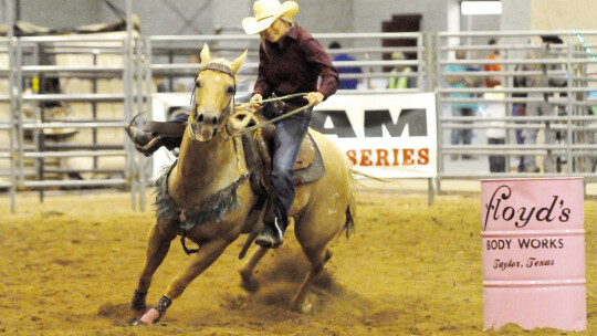 Rodeo participant competes in barrel racing contest, which involves racing a horse around a set path of barrels in a timed event. Photos from Staff Files