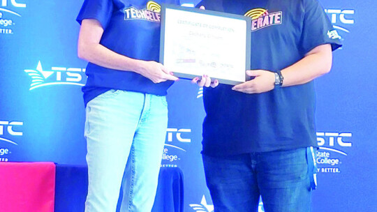 Zachary Gibson (right) receives a certificate of completion after attending the TECHcelerate conference at TSTC in Waco.