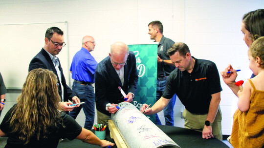 Mayor Brandt Rydell (middle) signs an honorary pipe, which all guests were asked to sign to remember the occasion.