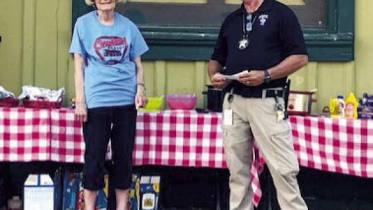 Depot Coordinator Barbara Piper introduces Sheriff’s Deputy Matt Kreidel at Coupland’s National Night Out.