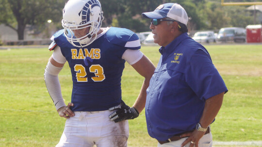 St. Mary’s varsity football junior quarterback Kolbe Barta talks with head coach Rick Cobia on Aug. 26 during the Rams’ home opener vs. Wilco Home School.