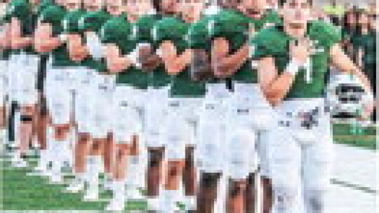 The Taylor High School varsity football team lines up behind senior Devin Valdez (1) for the national anthem on Sept. 1 prior to the Ducks’ home game vs. rival Rockdale High School. Photo by Larry Pelchat