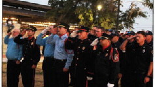 Honor Guard Academy students and first responders salute the flag.